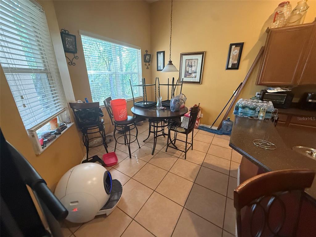 A kitchen dining area features tile flooring, a round table with chairs, and yellow walls — 449 KAYS LANDING DRIVE, SANFORD, FL