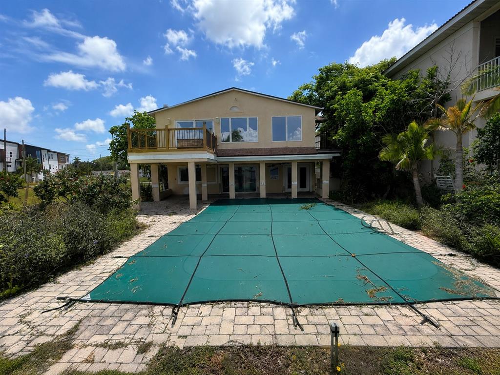 A two-story house with a wooden deck and a covered swimming pool in the backyard — 6111 BAYOU GRANDE BOULEVARD NE, ST PETERSBURG, FL