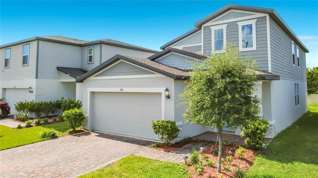 A two-story suburban house with a gray garage, blue siding, and a paved driveway — 1836 CARNOSTIE ROAD, WINTER HAVEN, FL