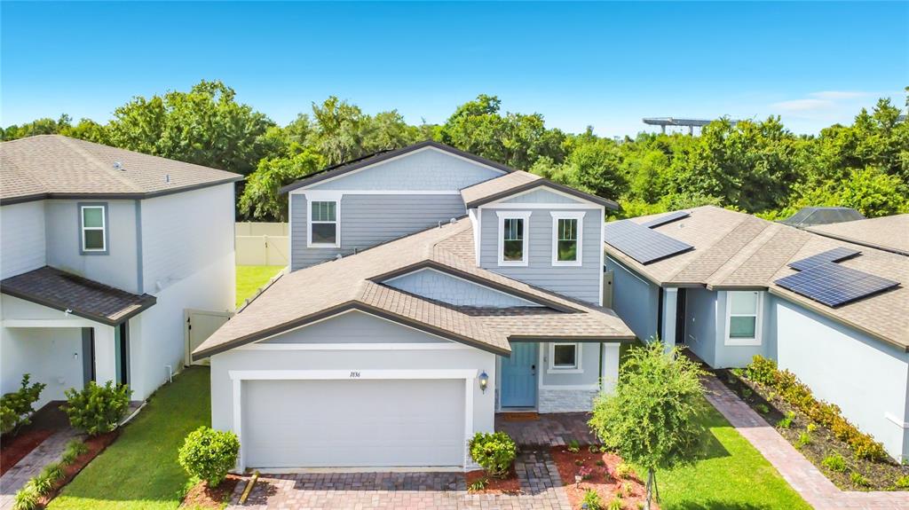 An aerial view of a two-story suburban house with a garage and light blue siding — 1836 CARNOSTIE ROAD, WINTER HAVEN, FL