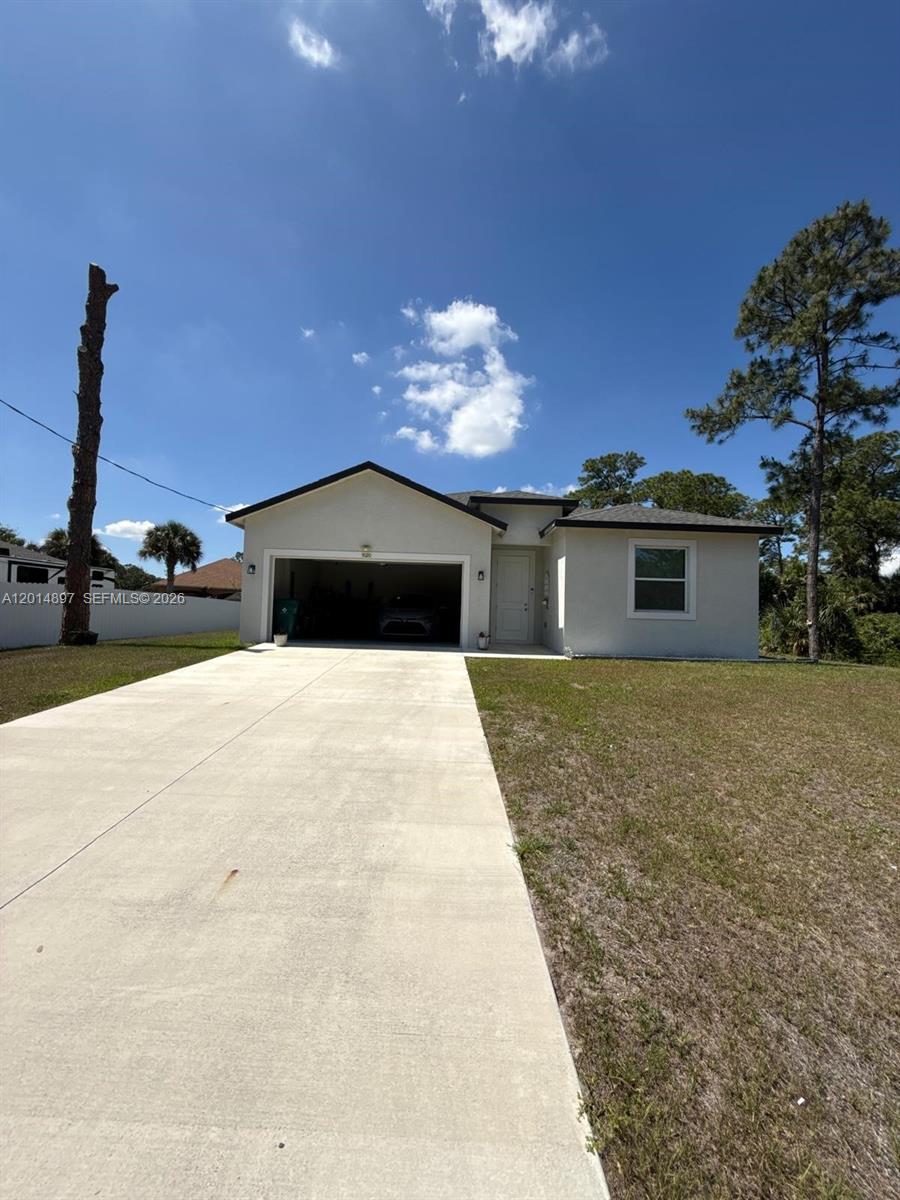 A single-story house with a white exterior, a two-car garage, and a concrete driveway — 5020 Myrtlewood RD, La Belle FL 33935, LA BELLE, FL
