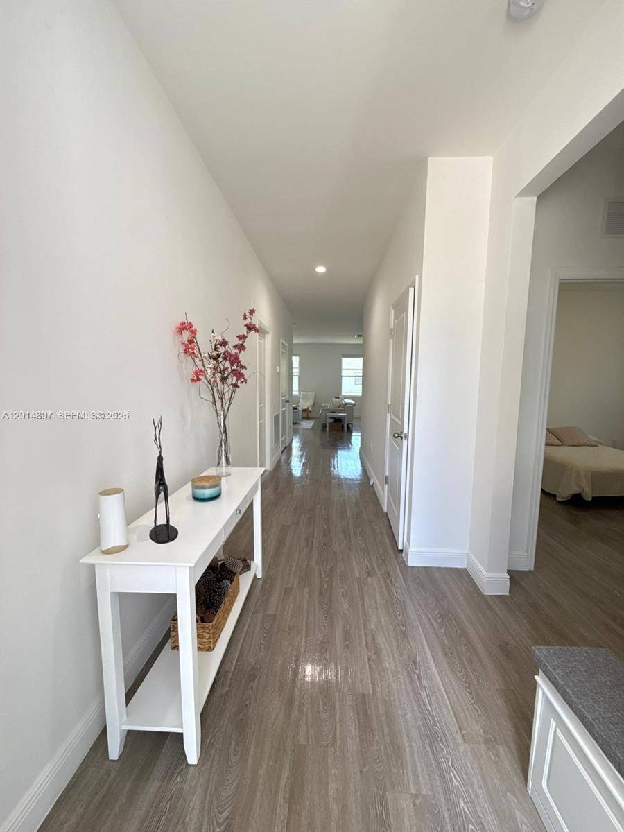 A long hallway with light wood-look flooring leads to an open living area — 5020 Myrtlewood RD, La Belle FL 33935, LA BELLE, FL