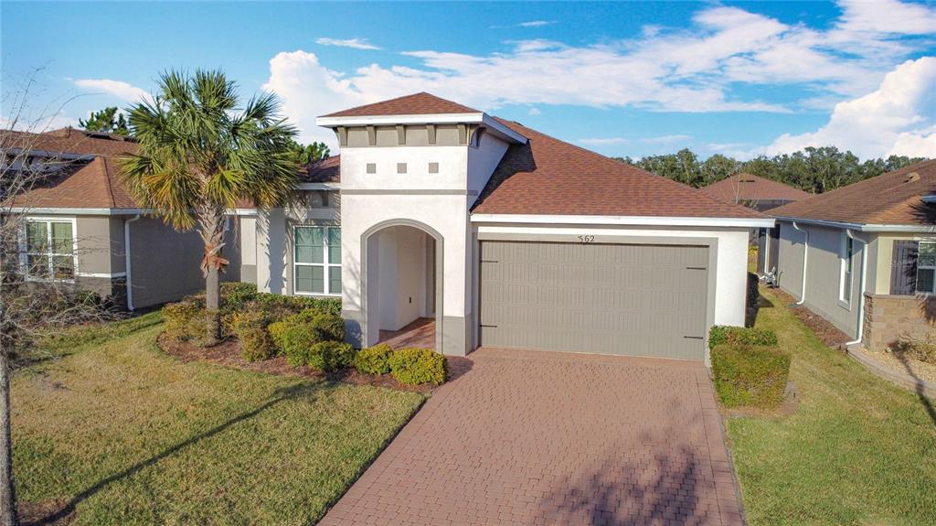 A single-story suburban house with a brown roof, stucco exterior, and a paved driveway — 362 VIA TORRENTE DRIVE, KISSIMMEE, FL