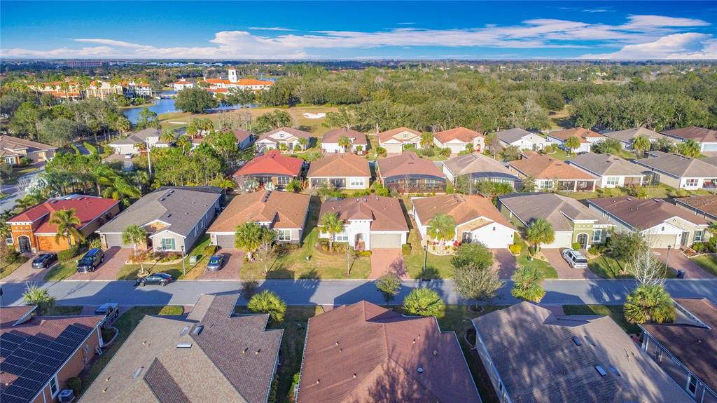 An aerial view shows a suburban neighborhood with single-family homes and a nearby golf course — 362 VIA TORRENTE DRIVE, KISSIMMEE, FL