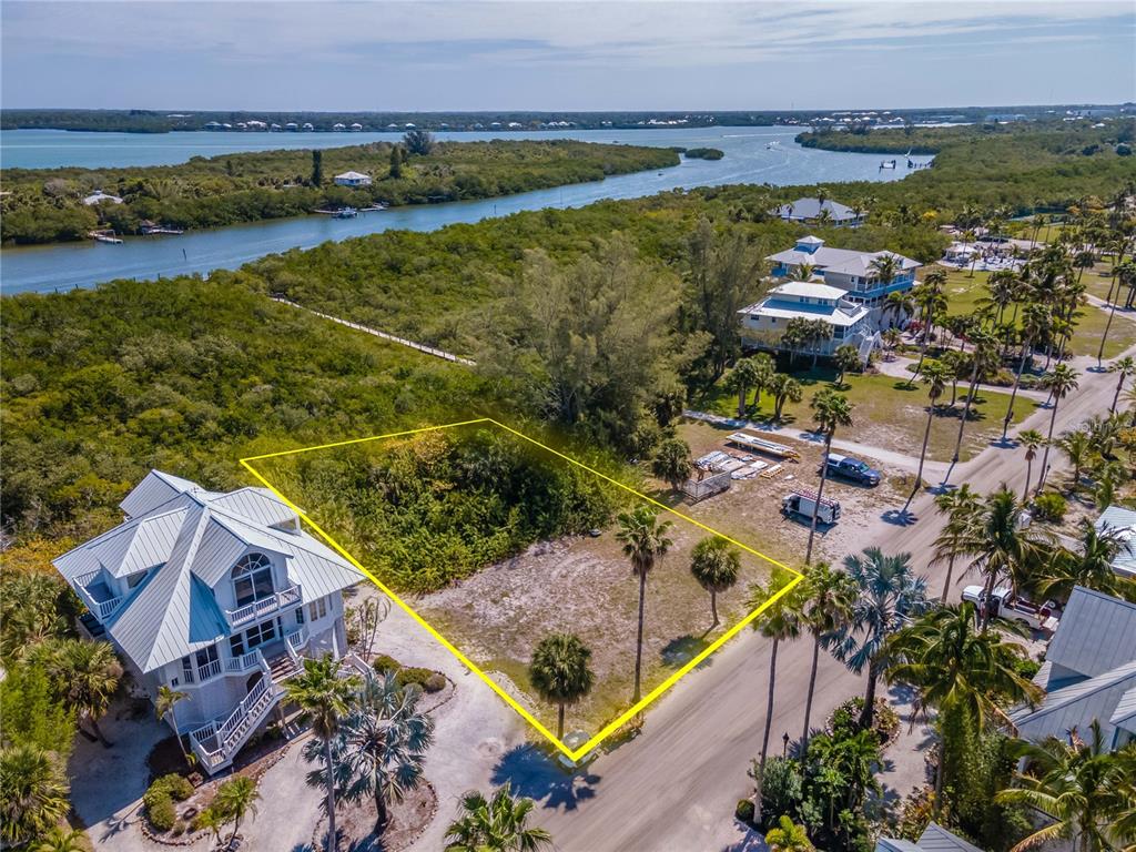 An aerial view shows a vacant, rectangular lot outlined in yellow next to a house — 7395 PALM ISLAND DRIVE Lot 22, PLACIDA, FL