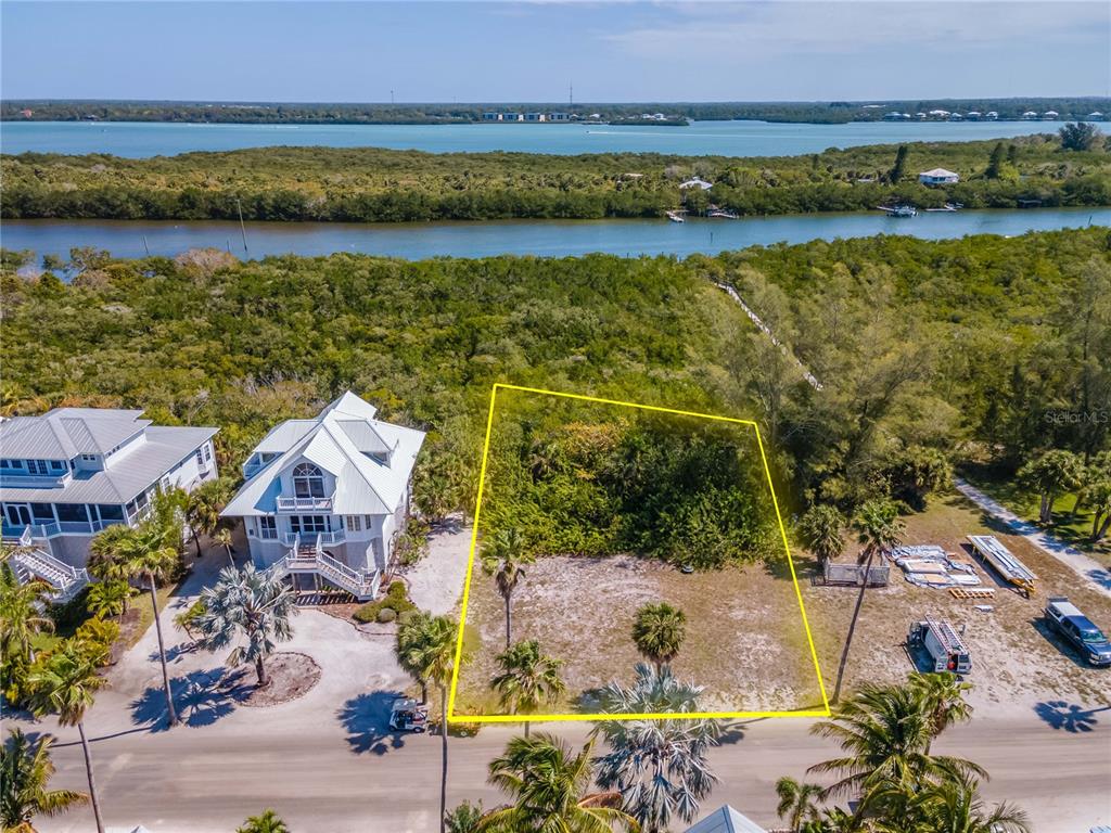An aerial view shows a vacant, rectangular lot outlined in yellow next to a house — 7395 PALM ISLAND DRIVE Lot 22, PLACIDA, FL