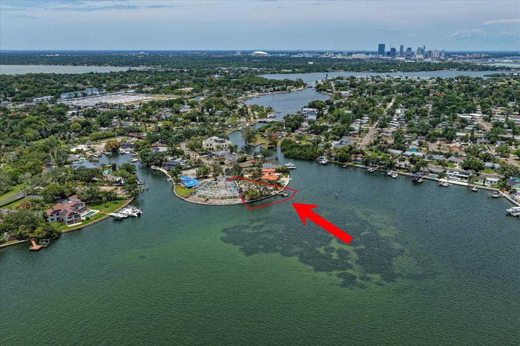 An aerial view shows a waterfront home on a point with a screened pool enclosure — 4838 PARADISE WAY S, ST PETERSBURG, FL