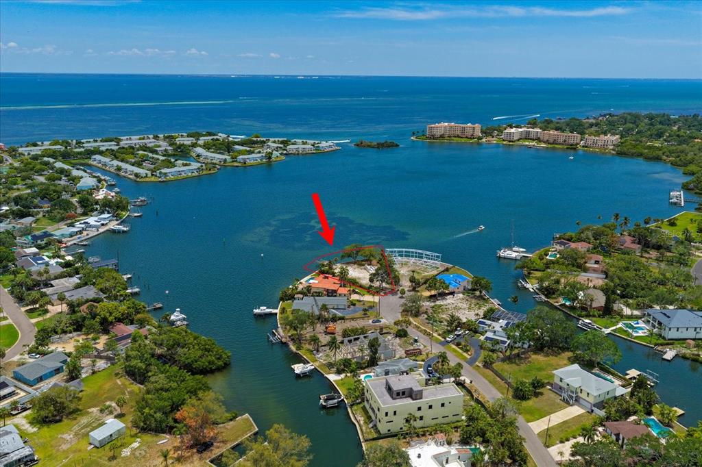 An aerial view shows a waterfront residential lot with a red arrow pointing toward it — 4838 PARADISE WAY S, ST PETERSBURG, FL