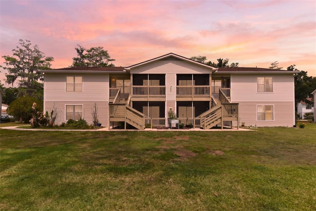 A two-story apartment building with light siding, screened balconies, and wooden exterior staircases — 1600 BIG TREE ROAD UNIT G3, SOUTH DAYTONA, FL