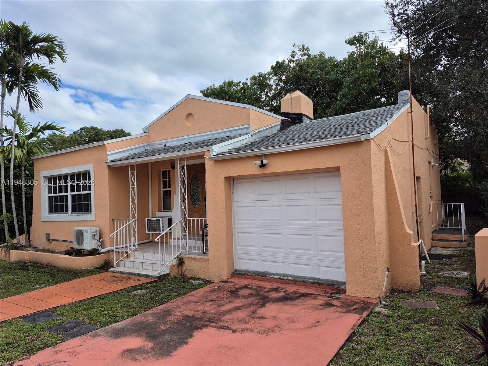 A single-story peach-colored house features a front-facing garage, a small porch, and a driveway — 28 NE 49th St # 0, Miami FL 33137, MIAMI, FL