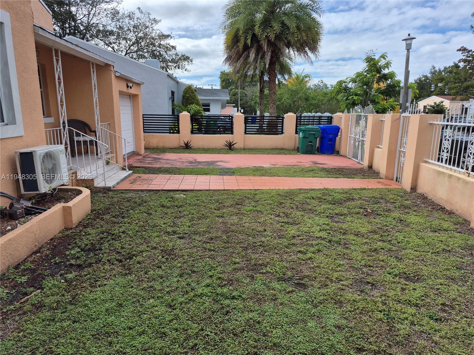 A front yard with a tiled walkway, a concrete driveway, and a low stucco wall — 28 NE 49th St # 0, Miami FL 33137, MIAMI, FL