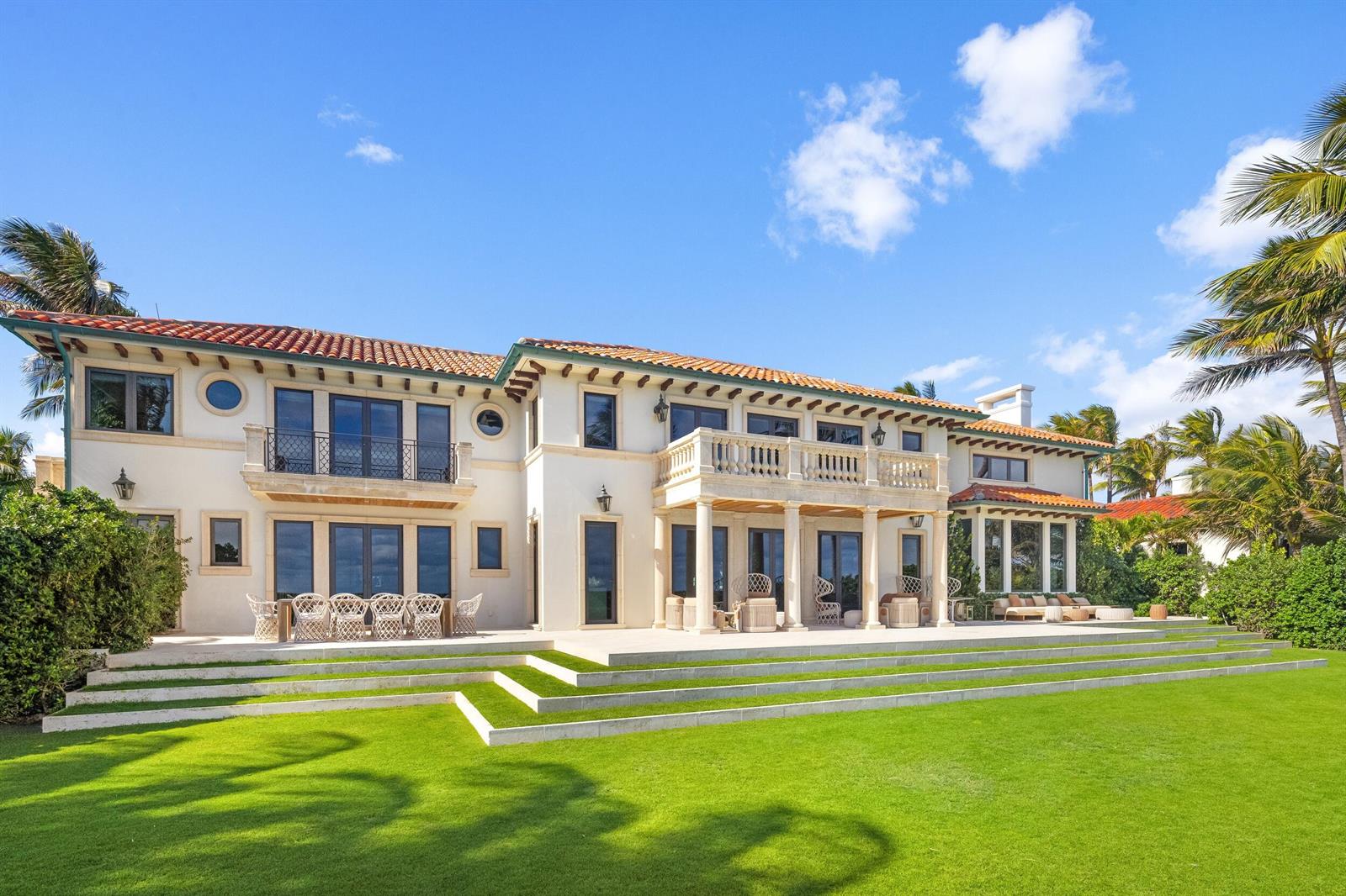 The exterior of a large Mediterranean-style house features a tiled roof, stone balcony, and patio — 680 S Ocean Boulevard, Palm Beach FL 33480, PALM BEACH, FL