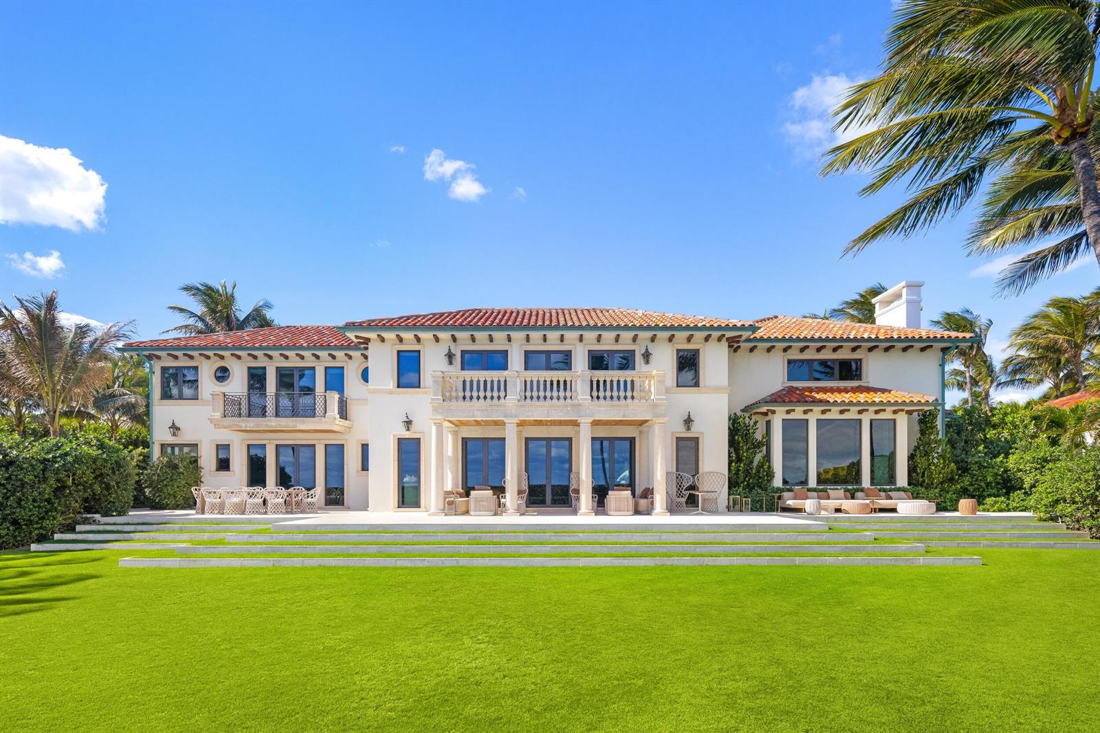 The rear exterior of a large two-story Mediterranean-style villa with a manicured lawn — 680 S Ocean Boulevard, Palm Beach FL 33480, PALM BEACH, FL