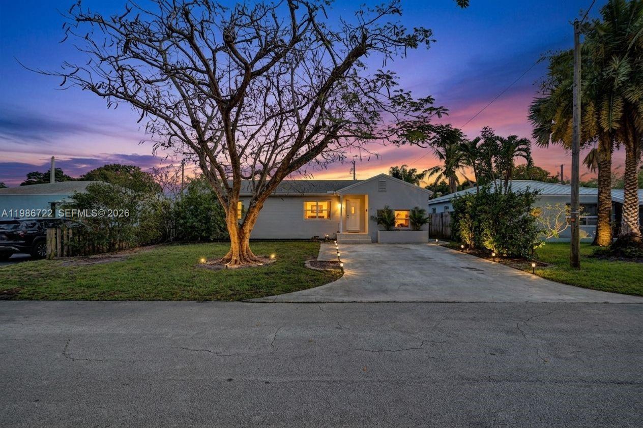 A single-story house with a concrete driveway and a large tree in the front yard — 1508 Funston St, Hollywood FL 33020, HOLLYWOOD, FL
