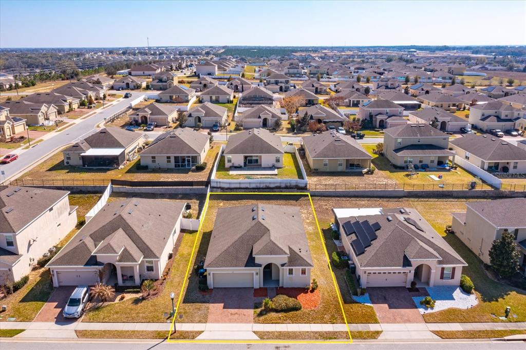 An aerial view shows a suburban single-family home with a tan exterior and gray roof — 339 MARIVAL DRIVE, DAVENPORT, FL