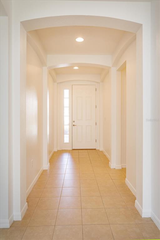 A tiled hallway features arched ceilings and leads to a white front door — 339 MARIVAL DRIVE, DAVENPORT, FL