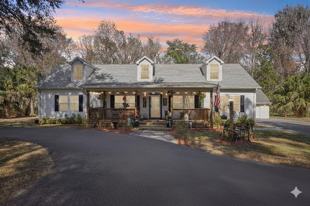 A single-story house with a covered front porch, dormer windows, and a paved driveway — 7459 SW 5TH AVENUE, OCALA, FL