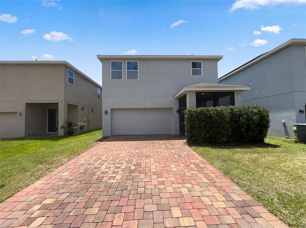 A two-story house with a paved driveway, a two-car garage, and a screened-in porch — 2264 FICUS ALLEY, APOPKA, FL