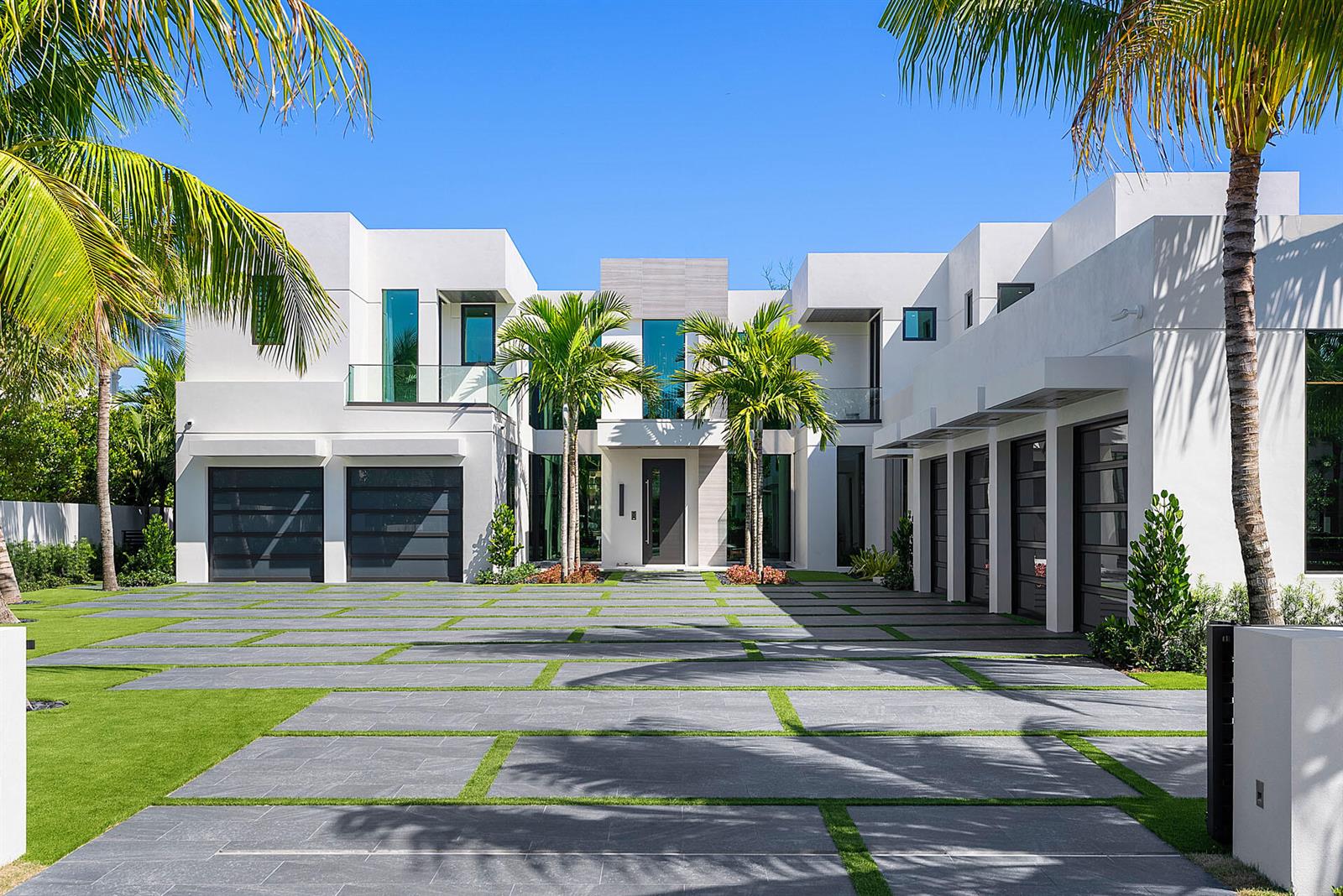 A modern white two-story house with a large paved driveway and multiple garage doors — 372 E Alexander Palm Road, Boca Raton FL 33432, BOCA RATON, FL