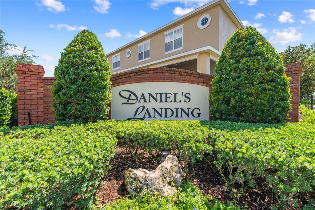 A brick monument sign for Daniel's Landing stands in front of a multi-story apartment building — 241 DEEPCOVE ROAD, WINTER GARDEN, FL