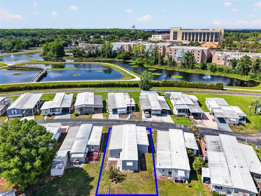 An aerial view shows a mobile home highlighted in blue within a residential community — 465 MARINA LANE, TAVARES, FL