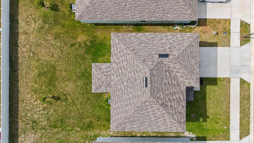 An aerial view shows the shingled roof of a house with a large backyard — 169 BORLAND STREET, BROOKSVILLE, FL