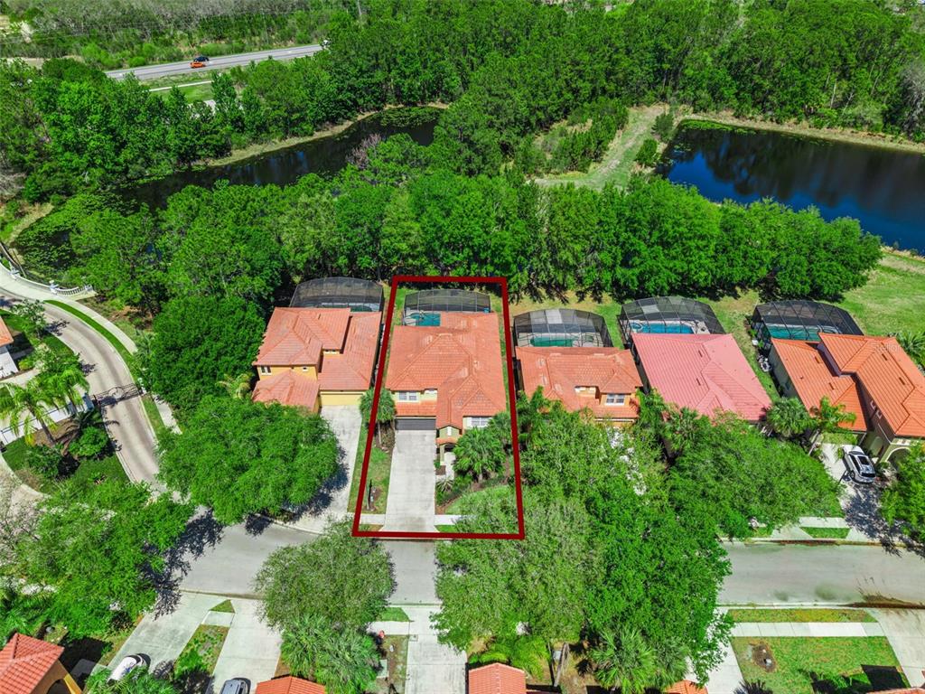 An aerial view shows a residential house with a red tile roof and pool enclosure — 110 ORANGE COSMOS BOULEVARD, DAVENPORT, FL