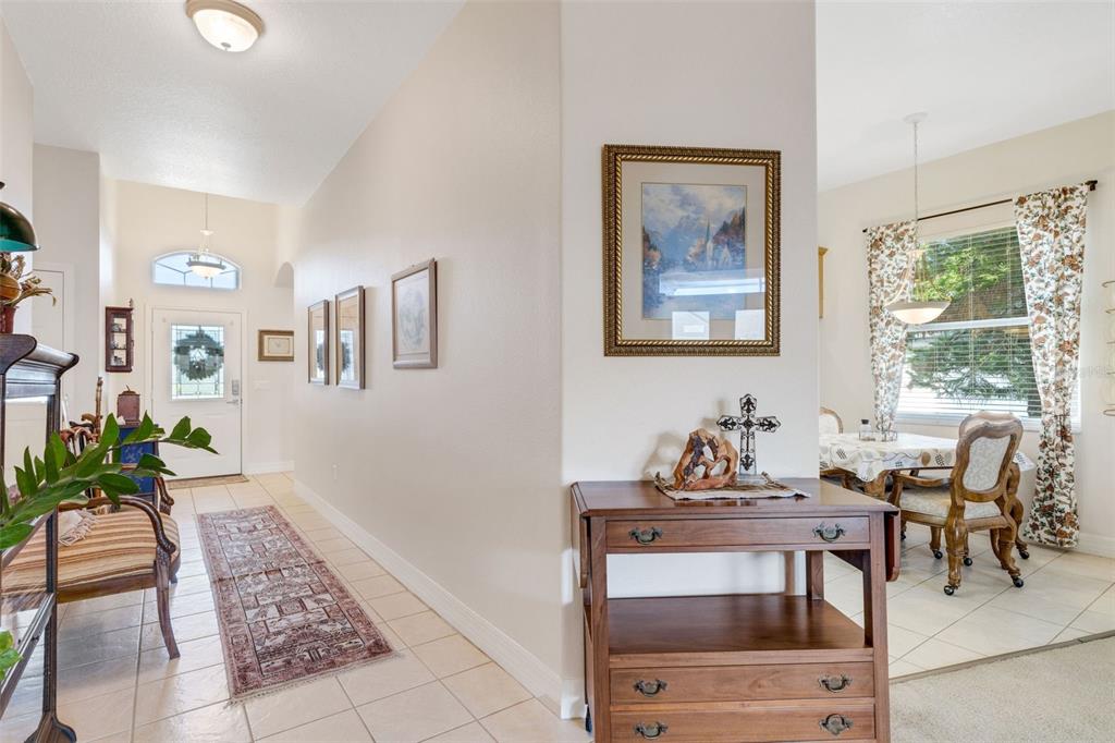 A tiled entryway leads to a front door, with a wooden console table nearby — 2617 HICKORY VIEW LOOP, LAKELAND, FL
