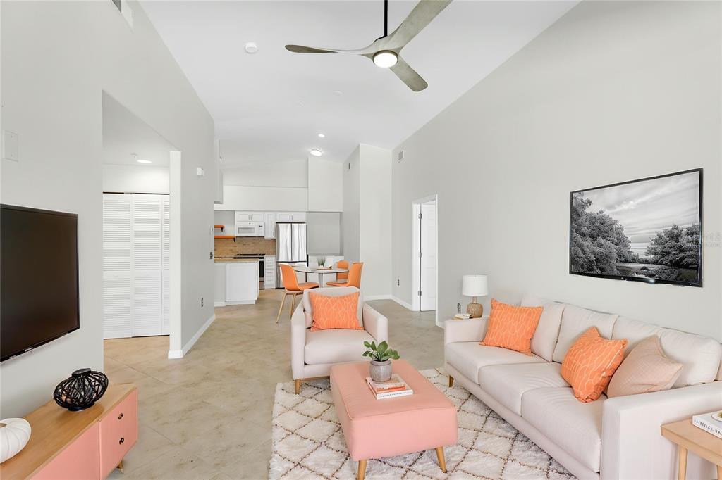 A living room with a sofa, armchairs, and an open kitchen in the background — 4244 CENTRAL SARASOTA PARKWAY UNIT 726, SARASOTA, FL