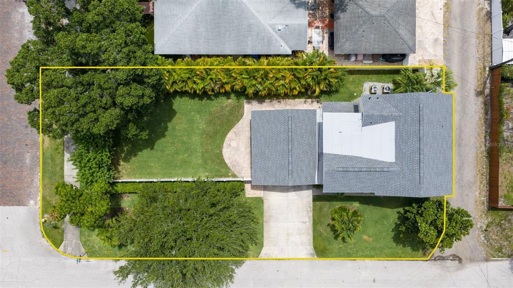 An aerial view shows a house with a gray roof, a driveway, and a fenced yard — 1470 28TH AVENUE N, ST PETERSBURG, FL