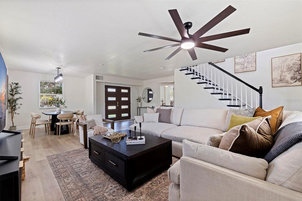 A living room with a sectional sofa, coffee table, and staircase leading to an upper level — 1470 28TH AVENUE N, ST PETERSBURG, FL