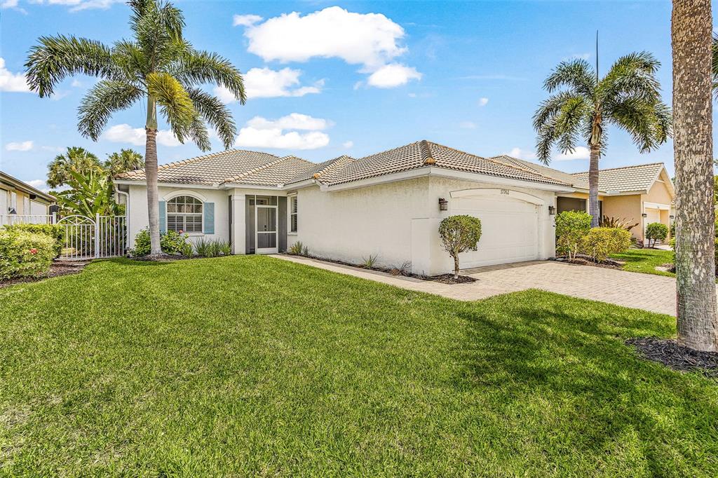 A single-story house with a white stucco exterior, a two-car garage, and two palm trees — 17762 COURTSIDE LANDINGS CIRCLE, PUNTA GORDA, FL