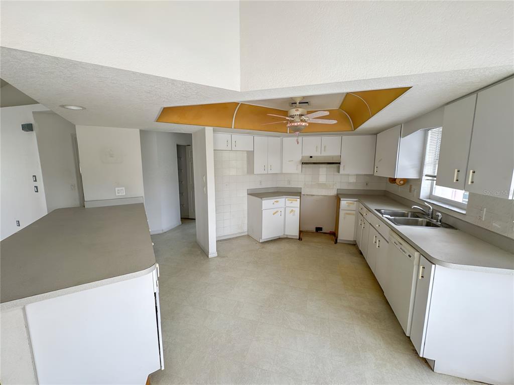 A kitchen with white cabinets, gray countertops, a ceiling fan, and a tiled backsplash — 5431 S CRANBERRY BOULEVARD, NORTH PORT, FL