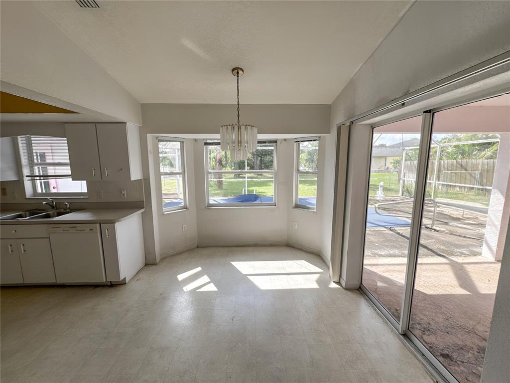 A kitchen dining area features white cabinets, a bay window, and a sliding glass door — 5431 S CRANBERRY BOULEVARD, NORTH PORT, FL