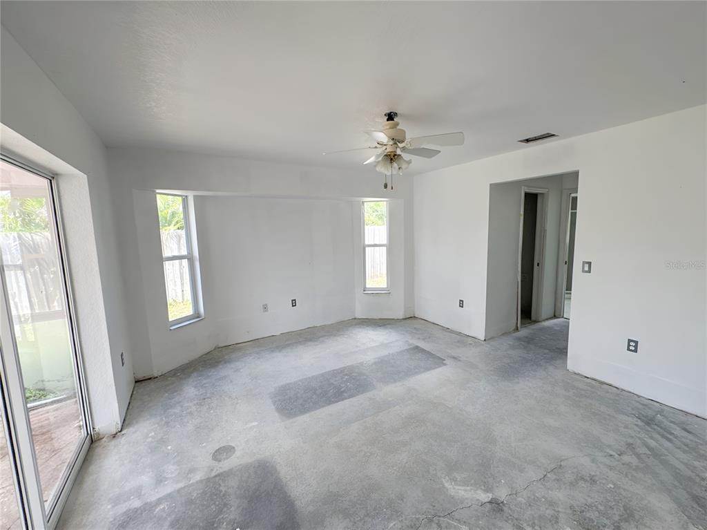 An empty room with white walls, a ceiling fan, and unfinished concrete flooring — 5431 S CRANBERRY BOULEVARD, NORTH PORT, FL