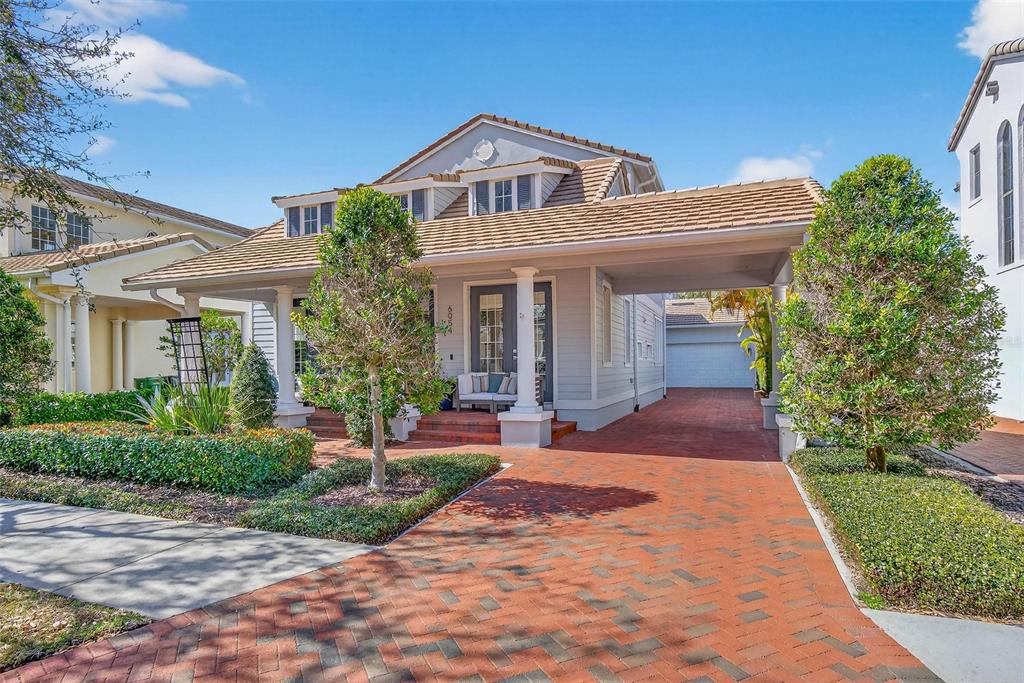A two-story house with a brick driveway, a covered carport, and a front porch — 6054 YEATS MANOR DRIVE, TAMPA, FL