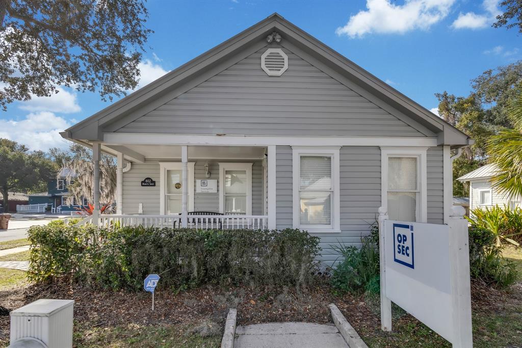 A gray, single-story house with a front porch and a prominent sign in the yard — 802 MABBETTE ST, KISSIMMEE, FL