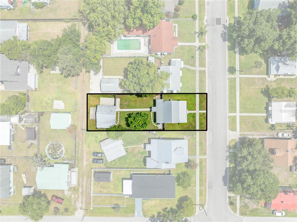 An aerial view shows a residential property lot outlined in black with a house and garage — 714 MASSACHUSETTS AVENUE, ST CLOUD, FL