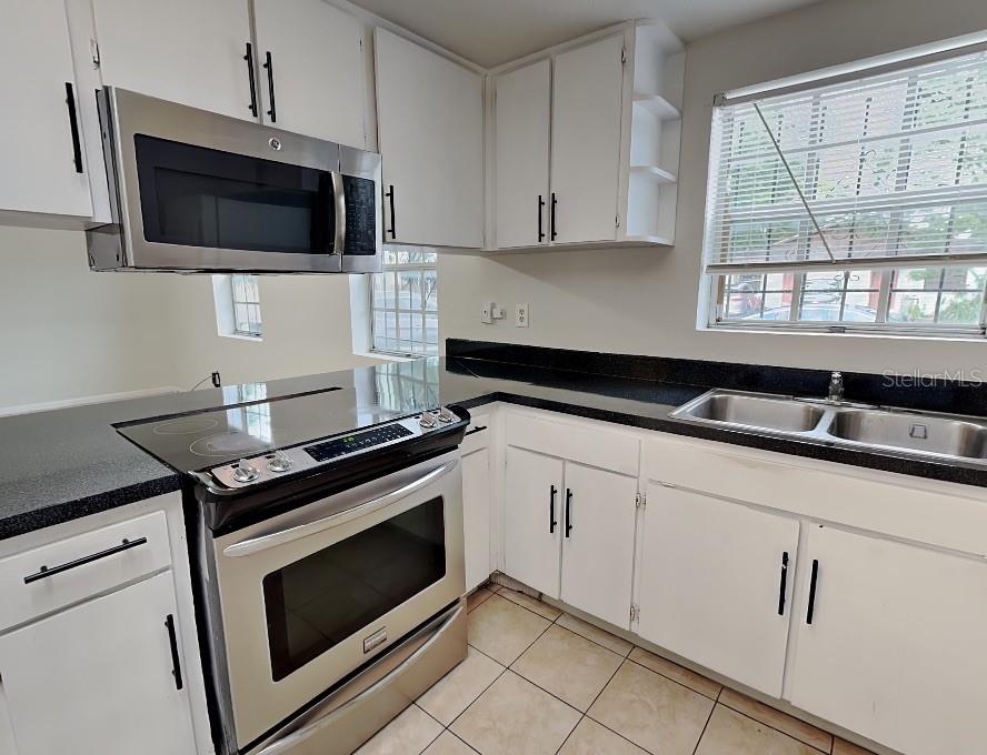 A room with light-colored walls, tile flooring, a ceiling fan, and an open closet — 9213 N 13TH STREET, TAMPA, FL