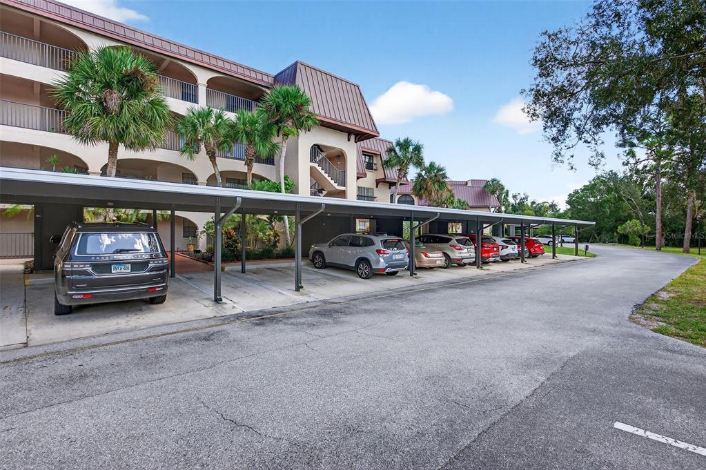 A multi-story apartment building with a covered parking structure in the foreground — 23465 HARBORVIEW ROAD UNIT 814, PUNTA GORDA, FL