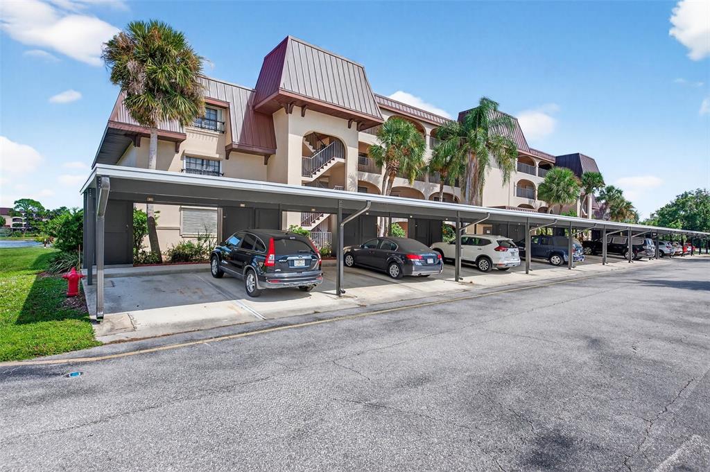 A multi-story apartment building with a covered parking structure in the foreground — 23465 HARBORVIEW ROAD UNIT 814, PUNTA GORDA, FL