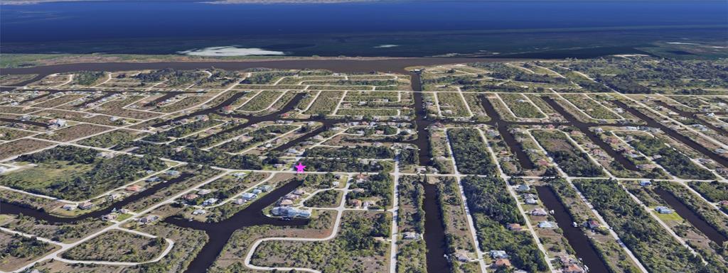 This aerial view shows a residential neighborhood with houses situated along a network of canals — 15249 RED HEAD AVENUE, PORT CHARLOTTE, FL
