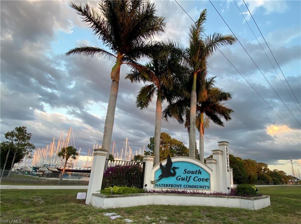 A sign for South Gulf Cove Waterfront Community stands before palm trees and a marina — 15249 RED HEAD AVENUE, PORT CHARLOTTE, FL