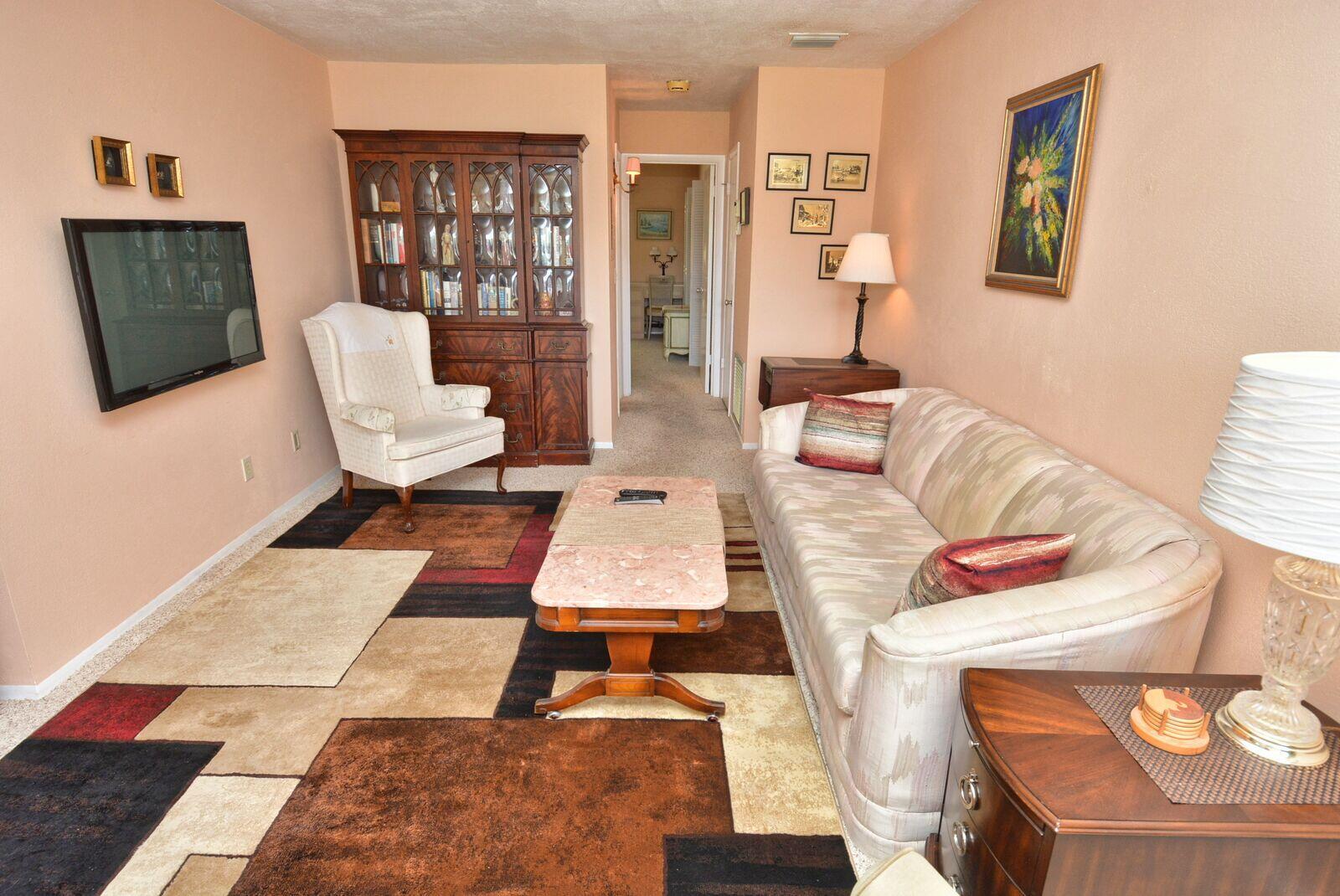 A living room features a patterned area rug, a sofa, an armchair, and a hutch — 1225 NW 21st Street # 2010, Stuart FL 34994, STUART, FL