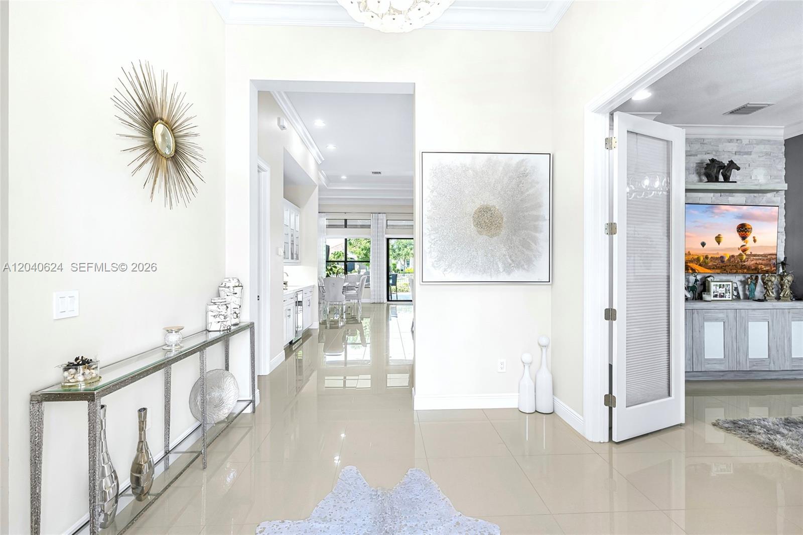A bright entryway features polished tile floors, a glass console table, and a large painting — 11930 Palermo Rd, Parkland FL 33076, PARKLAND, FL
