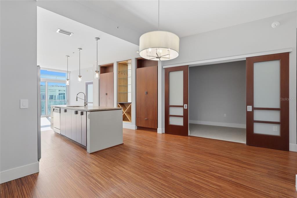 A kitchen with a center island and wood floors opens to a room with sliding doors — 111 N 12TH STREET UNIT 1811, TAMPA, FL