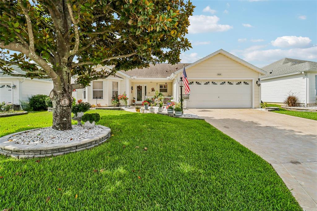 A single-story house with a large tree in the front yard and a paved driveway — 16581 SE 77TH NORTHRIDGE COURT, THE VILLAGES, FL