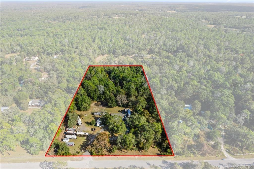 An aerial view shows a wooded lot with a house and several trailers — 16362 CHEROKEE ROAD, BROOKSVILLE, FL