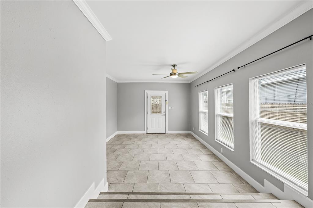 A bright room with light gray walls, tile flooring, a ceiling fan, and three windows — 5345 38TH AVENUE N, ST PETERSBURG, FL