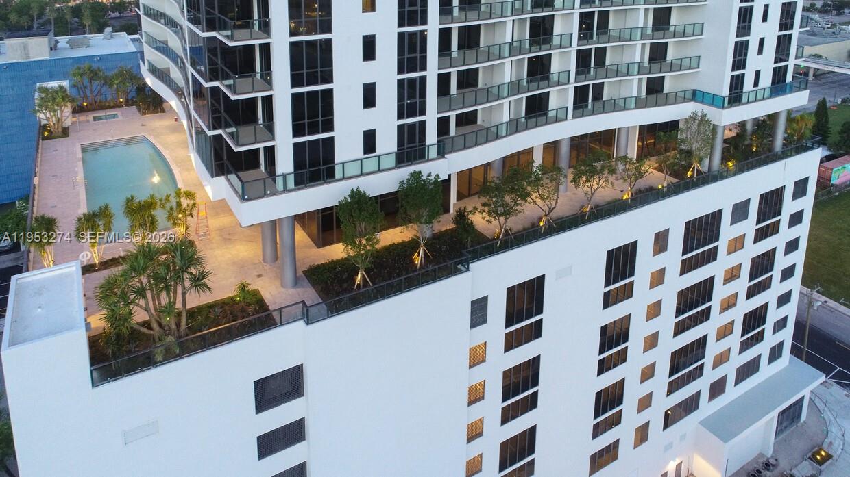 An aerial view shows a modern high-rise building with a pool deck and landscaping — 1600 NE 1st Ave # 1018, Miami FL 33132, MIAMI, FL